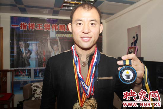 樊偉鵬向大家展示自己剛獲得的吉尼斯獎(jiǎng)牌。