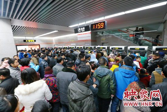 地鐵開通首日，上午十一點五十九分，紫荊山地鐵站售票機前擠滿了買票的市民。