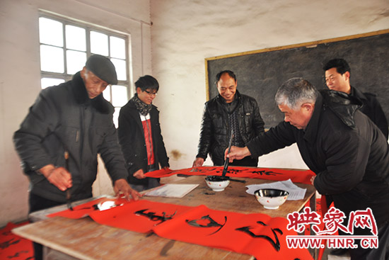 鞏義市魯莊鎮(zhèn)農(nóng)民書法愛好者正在寫春聯(lián)。