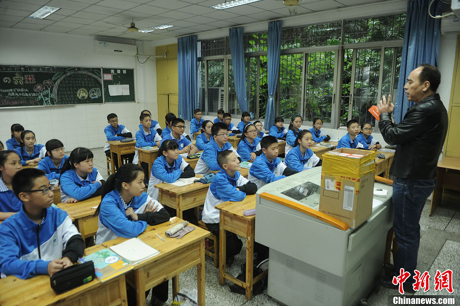 圖為老師正在向同學(xué)們講解用非智能手機(jī)對他們的好處。