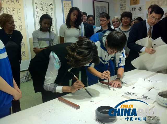 　北京時間3月21日，美國第一夫人米歇爾參觀北師大二附中時，與學(xué)生一起練習(xí)書法。