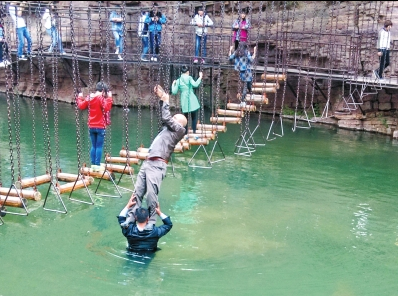 中年男游客正踩著景區(qū)安全員郭小明的肩膀過河。網(wǎng)友“@我的小名叫張孩”供圖