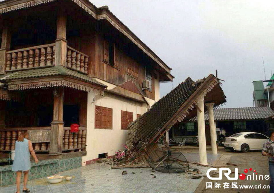 當?shù)貢r間2014年5月5日，泰國清萊，一名婦女看著受損的房屋。 圖片來源：東方IC