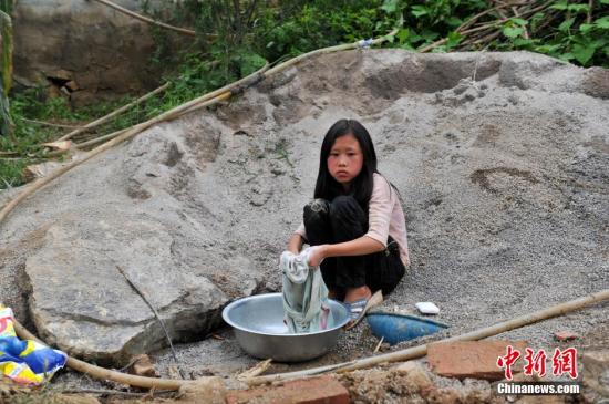 8月9日，云南巧家紅石巖村，10歲的劉鑫蕊在洗自己的衣服
