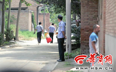 昨日,西安市閻良區(qū)譚家村,警方在事發(fā)的孫某家里勘查現(xiàn)場后,將提取的物證帶走 華商報(bào)記者 黃利健 攝