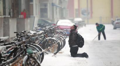 小伙子跪在樓前，一直抬頭看著樓上。 孫立國/攝