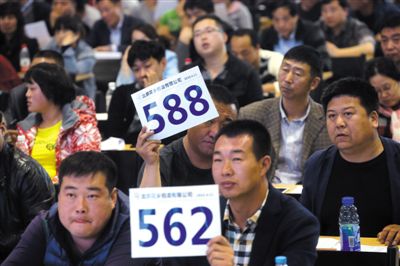 昨日，拍賣現(xiàn)場競拍者舉牌競拍。新京報記者