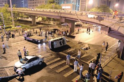 路虎沖下國(guó)貿(mào)橋砸中一輛起亞轎車(chē)，橋上厚達(dá)幾十厘米的水泥護(hù)欄被撞斷，碎石四處散落，數(shù)十群眾在現(xiàn)場(chǎng)圍觀。