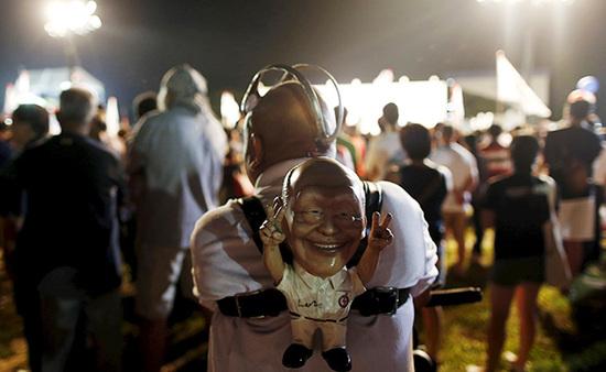 9月4日，新加坡，執(zhí)政黨的一場(chǎng)集會(huì)上，一名支持者背著一個(gè)李光耀的人偶。