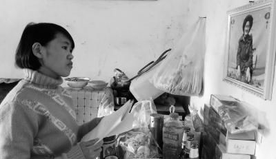 錢仁鳳站在母親遺像前。未能見母親最后一面是她的一大遺憾。