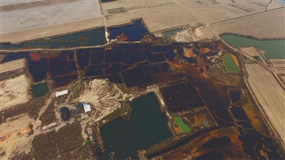 4月19日，廊坊市大城縣南趙扶鎮(zhèn)，津保路以北約八九百米處，一個巨大的污水坑中，水體呈現(xiàn)紅褐色。 新京報記者 尹亞飛 攝