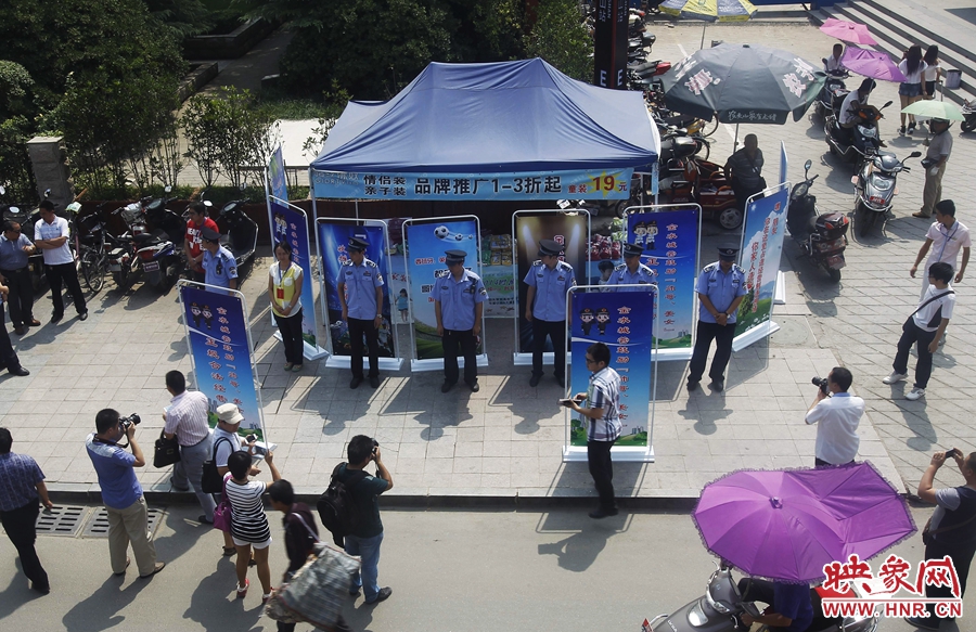 執(zhí)法人員用宣傳牌圍擋占道經(jīng)營攤位。