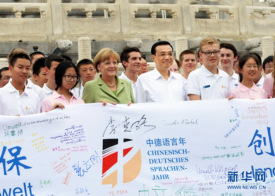 李克強(qiáng)同默克爾與青少年在天壇祈年殿前合影留念。