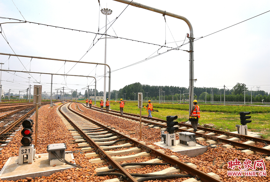 在太陽的直射下，檢修工人扛著沉重的設(shè)備向施工地點(diǎn)出發(fā)