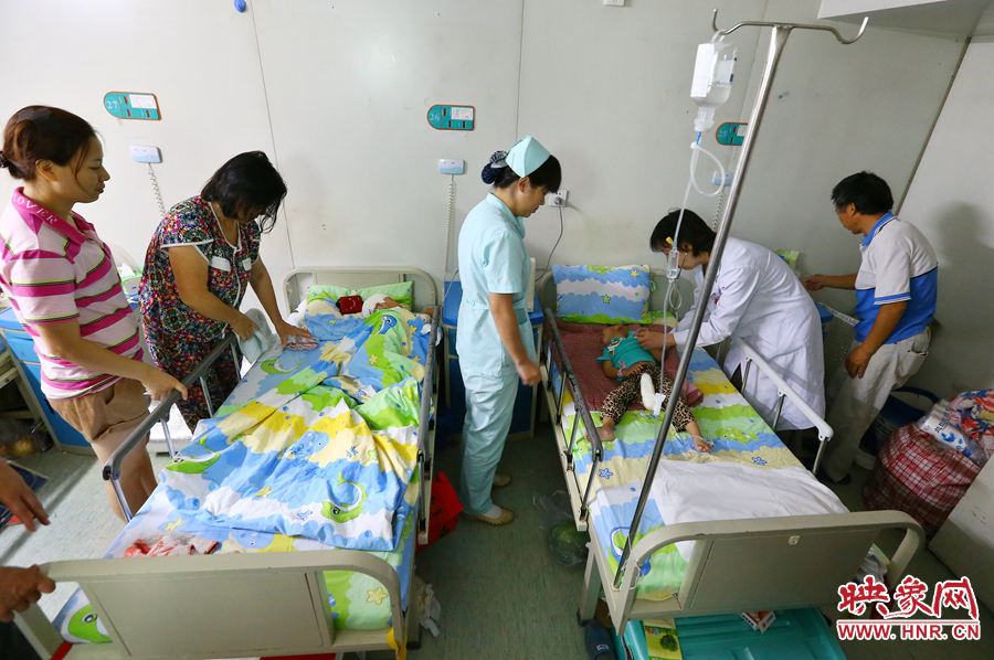 手術(shù)前，畫面右側(cè)的大龍正在接受醫(yī)生的檢查，左側(cè)的小龍還在熟睡。