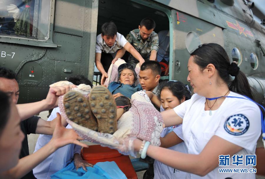 8月5日，醫(yī)護(hù)人員將一名通過直升機(jī)從震中轉(zhuǎn)運(yùn)出來的傷員運(yùn)下飛機(jī)。