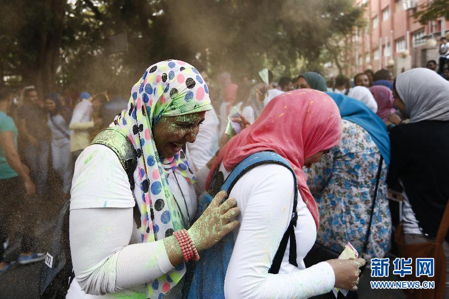 10月16日，在埃及首都開羅，兩名女青年在“彩色跑”活動中躲避人們拋撒的彩色粉末。