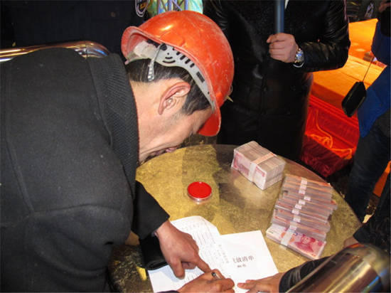 農(nóng)民工在現(xiàn)場領(lǐng)取工資。
