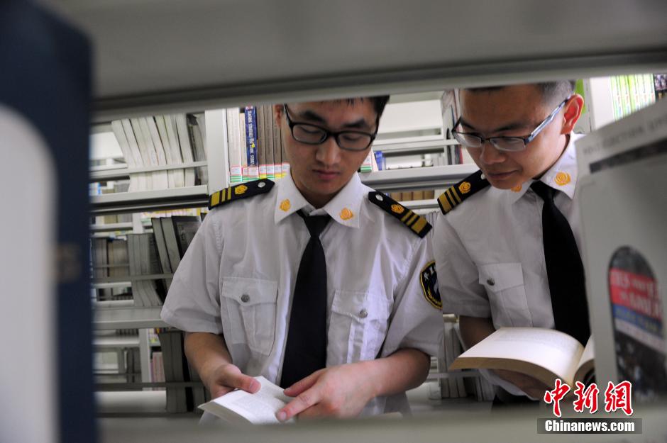 5月8日，武漢輕工大學(xué)圖書館保安吳濤與江力在圖書館交流學(xué)習(xí)。