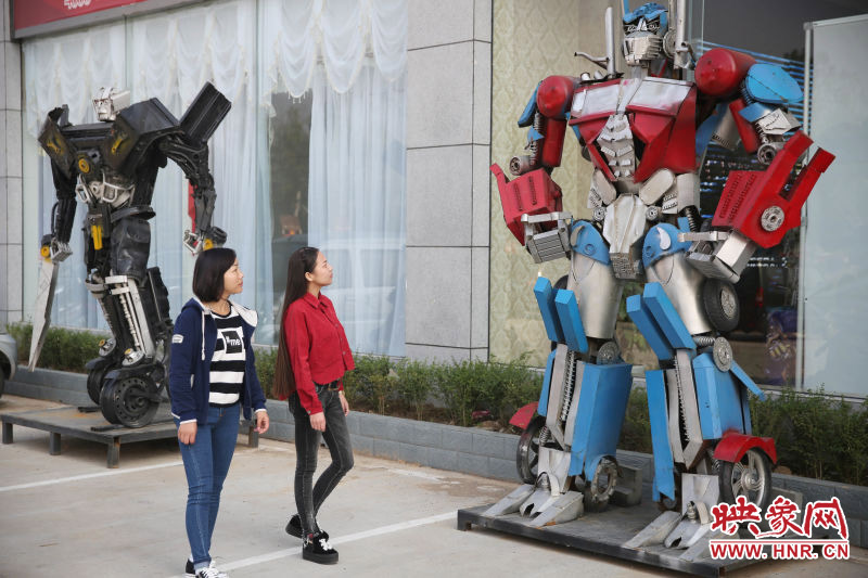 10月14日，市民在參觀河南省平頂山市寶豐縣一家企業(yè)門前的“變形金剛”。