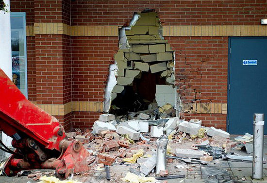 劫匪利用挖掘機(jī)的機(jī)械臂移走ATM機(jī)，留下滿地狼藉