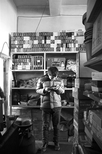 1月21日，周瑋在自家的超市里玩計算器。