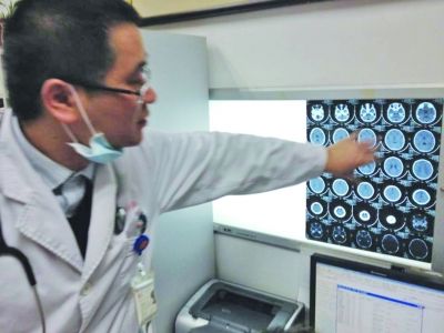 醫(yī)生在查看男孩的腦部CT片。薛馬義 攝