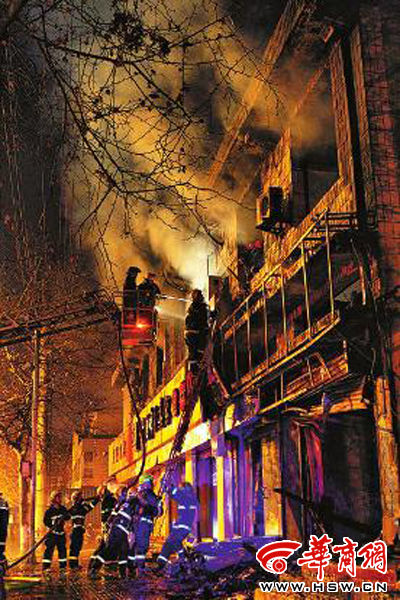 昨日22時(shí)10分，西安市豐慶路南小巷南口，消防官兵架梯子登上二樓施救 本組圖片由本報(bào)記者 閆文青 攝