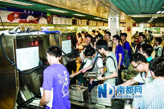 昨日，華南理工大學(xué)一食堂內(nèi)，學(xué)生們正在使用新安裝的自動(dòng)打飯機(jī)打飯。中新社發(fā)