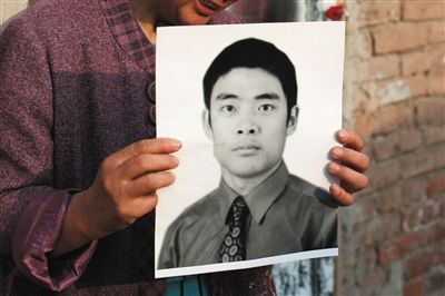 5月19日，朝陽北路，母親捧著張東文的遺像。新京報記者 侯少卿 攝