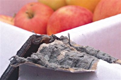 8月29日，新發(fā)地市場，一箱用“加重紙箱”包裝的蘋果正待售，紙箱夾層內(nèi)灰黑色的增重填充物清晰可見