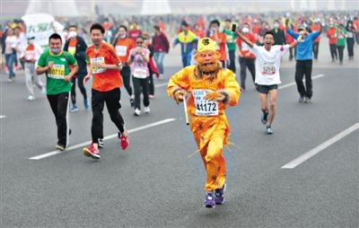 長(zhǎng)安街，一名打扮成孫悟空的參賽者在北馬隊(duì)伍里飛奔。 本版攝影/新京報(bào)記者 吳江 李飛 王嘉寧 吳江