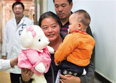 昨日上午，被扎針女嬰的母親抱著孩子和醫(yī)護(hù)人員送的玩偶準(zhǔn)備出院，院方稱孩子術(shù)后恢復(fù)良好。記者 高瑋 攝