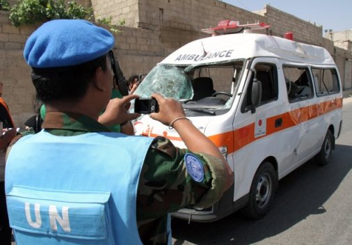 　一名聯合國監(jiān)督團成員在大馬士革郊區(qū)為一輛被毀救護車拍照