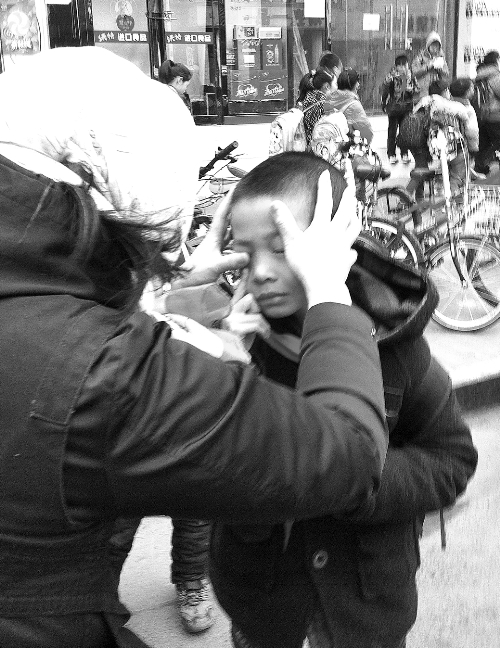 春天風(fēng)沙大，一孩子被風(fēng)沙瞇了眼