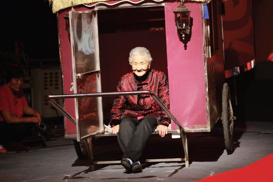 老母親坐著特制的板車(chē)十分開(kāi)心