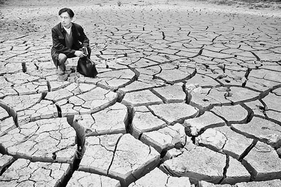 蹲在干涸的田地里，焦裕祿為饑餓的百姓揪心不已 《焦裕祿》劇照
