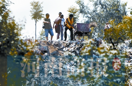 有人正在傾倒建筑垃圾，不遠(yuǎn)處就是村民的水井